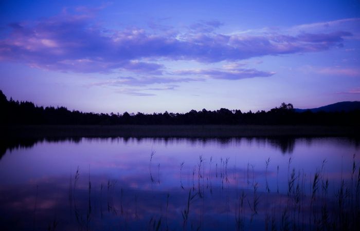 A serene landscape with calm water reflecting the sky.