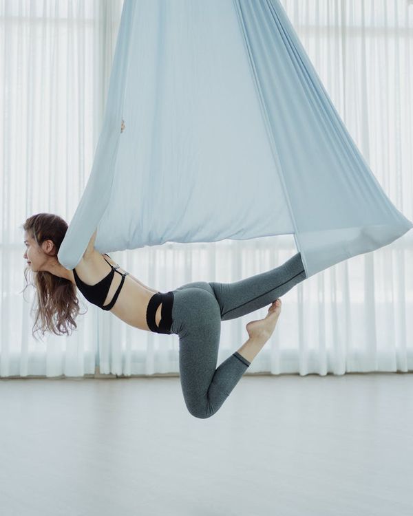 Woman in a calm and focused yoga pose in a modern studio.